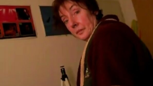 En varm brunette trækker i en stor pik foran os på sengen